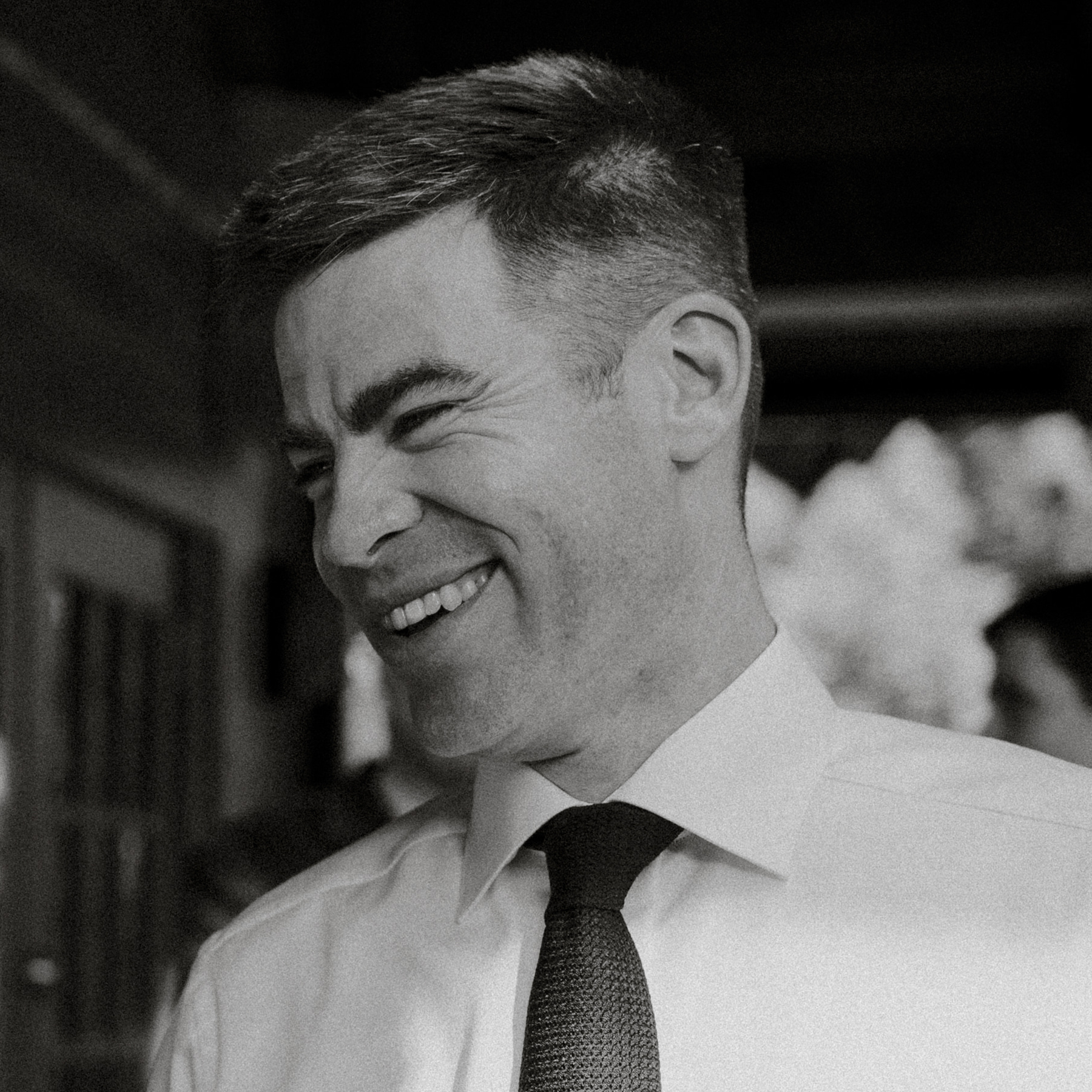 Professional IT services image showing A man in a dress shirt and tie smiles and laughs, looking left. The black-and-white image conveys a friendly, collaborative atmosphere. for managed IT services, cybersecurity, network infrastructure, cloud solutions, and business IT support. - BKY Technologies Professional IT services image showing A man in a dress shirt and tie smiles and laughs, looking left. The black-and-white image conveys a friendly, collaborative atmosphere. for managed IT services, cybersecurity, network infrastructure, cloud solutions, and business IT support.